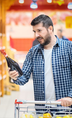 man looking at wine bottle