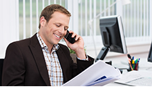 man in office on phone smiling
